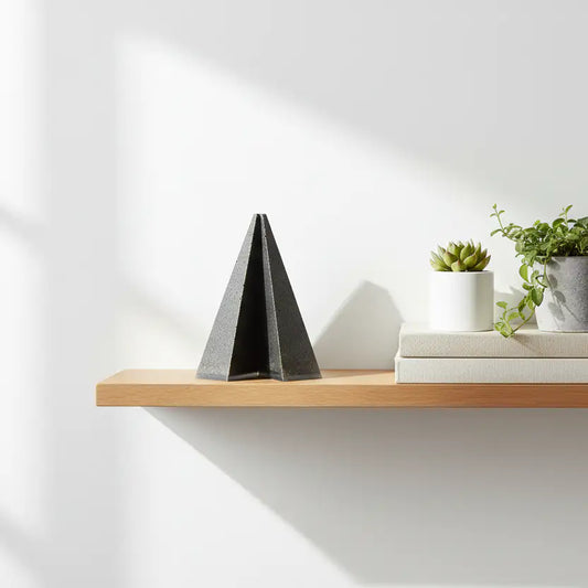 Urne cinéraire pyramidale PRISME pour animal de compagnie, posée sur une étagère à la décoration minimaliste et épurée